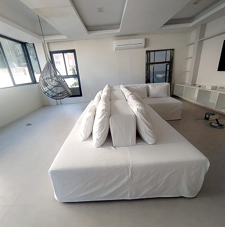 Capa de sofá sob medida branca em sala ampla com vista para o mar