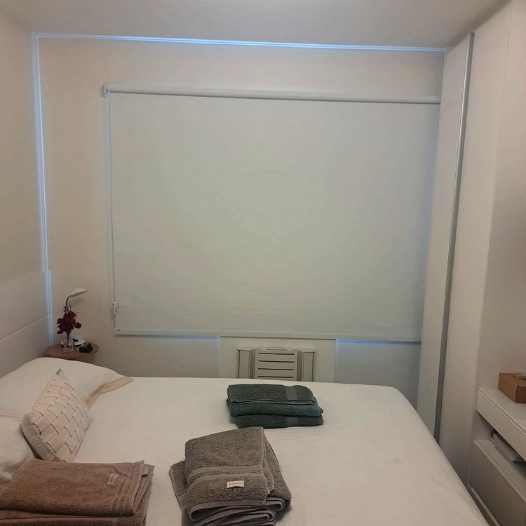 Persiana rolô branca sob medida em quarto de casal